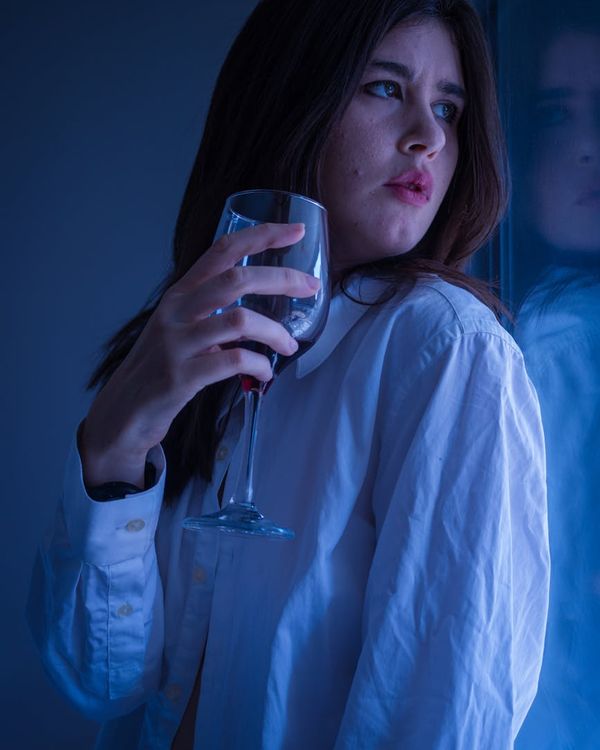 Woman in a peaceful relaxation pose in a dark, calm room.